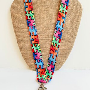 thumbnail interactive-video image 1 of PinMart's Autism Awareness ID Lanyard With Puzzle Piece Keychain – Safety Breakaway, Brand New 1 of 3