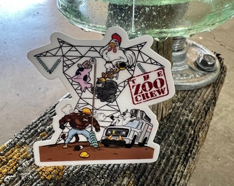 Pode incluir: Um adesivo branco com uma ilustração de desenho animado de um galo, um porco e um touro em uma linha de energia. O adesivo diz "The Zoo Crew" em letras vermelhas.
