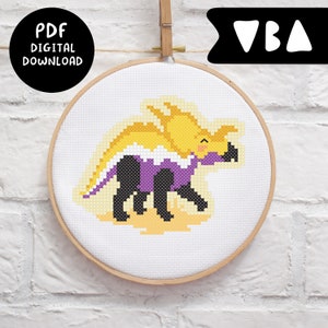 May include: Cross stitch pattern of a purple, yellow, and black triceratops with a cute expression. The pattern is in a wooden embroidery hoop. The text "PDF DIGITAL DOWNLOAD" is in a black circle at the top left of the image. The text "VBA" is in a black triangle at the top right of the image.