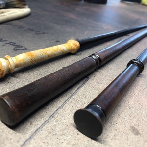 以下が含まれることがあります： 3本の木の杖。1本は先端が白と黄色に塗られており、2本は先端が黒く塗られている。