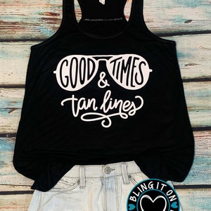 May include: Black tank top with white text that reads "Good Times & Tan Lines" with a pair of sunglasses graphic.