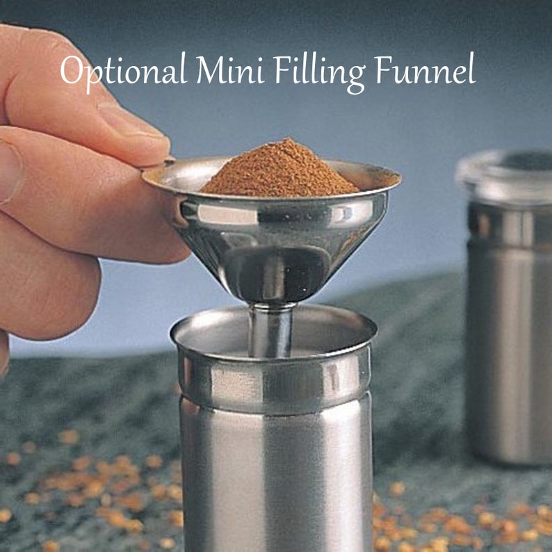 May include: A stainless steel mini filling funnel with a brown powder inside, being used to fill a stainless steel container.  Optional Mini Filling Funnel.