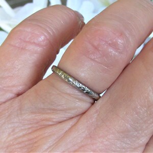Puede incluir: Una fina banda de plata con un delicado dise&ntilde;o floral. El anillo se lleva en un dedo.