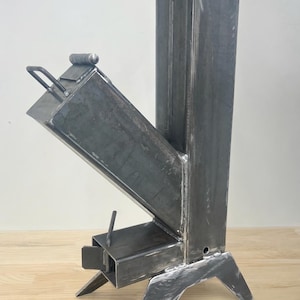 May include: A welded metal wood stove with a rectangular chimney and angled firebox. The stove has a handle on the firebox door and is supported by three angled legs. The word "PDF" is printed on the top left.