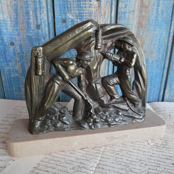 Antike französische Art Deco der 1930er Jahre patinierte Spelter-Skulptur mit flacher Rückseite von Bergleuten auf einem Marmorsockel