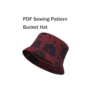Pode incluir: Um chapéu bucket bordô com um padrão floral de rosas pretas. O chapéu é feito de tecido e tem um formato clássico de chapéu bucket. O texto "PDF Sewing Pattern Bucket Hat" é exibido acima do chapéu.