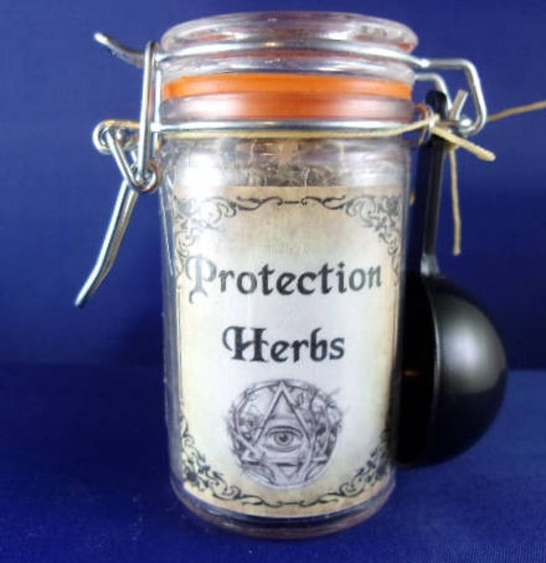 May include: A glass jar with a metal lid and a scoop. The jar is filled with dried herbs and has a label that says "Protection Herbs".