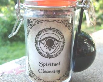May include: A clear glass jar with a metal wire bail closure and an orange rubber seal. The jar features a label with an eye symbol and the text Spiritual Cleansing. A black plastic scoop is attached to the side of the jar with a piece of twine.
