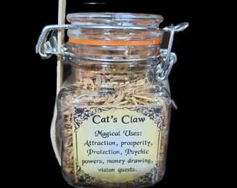 May include: A glass jar with a metal clasp lid filled with dried herbs. The label reads "Cat's Claw" and lists magical uses: attraction, prosperity, protection, psychic powers, money drawing, and vision quests.