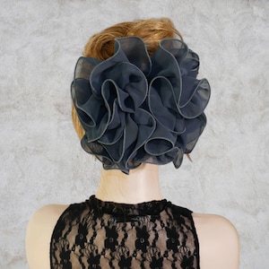 May include: A white ceramic mug with a black handle and the text "But First, Coffee" in a bold, black font. The mug is set against a blurred background, suggesting a cozy setting.