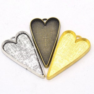 May include: Three heart-shaped metal pendant trays in silver, gold, and bronze. The trays are perfect for resin crafts and jewelry making.