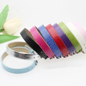 May include: A set of eight leather watch bands in various colors, including black, pink, blue, red, purple, green, white, and silver. The bands are all the same size and have a buckle closure.
