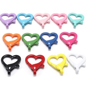 May include: Assortment of 12 heart-shaped metal clasps in various colours, including pink, blue, green, orange, red, yellow, black, and white.