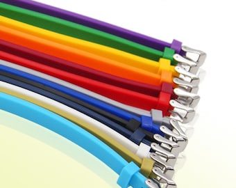 May include: A set of ten colourful silicone watch straps with silver buckles. The straps are arranged in a rainbow pattern, starting with purple and ending with light blue.
