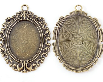 Puede incluir: Dos bandejas ovaladas de colgante de bronce antiguo con un borde decorativo. Una bandeja tiene una superficie lisa y la otra tiene un patrón de rayos de sol.