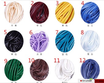Puede incluir: Doce carretes de cordón en varios colores, incluyendo crema, rojo, amarillo, azul, negro, morado, azul verdoso, blanco, verde, marrón y azul marino. Cada carrete está etiquetado con un número del 1 al 12.
