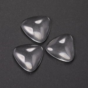 Op de afbeelding: Drie transparante glazen driehoeken op een zwarte achtergrond.