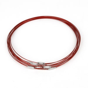 May include: A set of six red metal choker necklaces with silver clasps. The necklaces are stacked on top of each other.