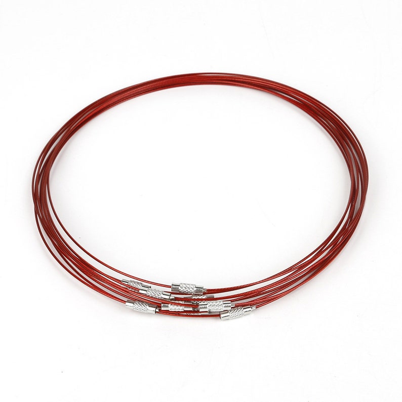 May include: A set of six red metal choker necklaces with silver clasps. The necklaces are stacked on top of each other.