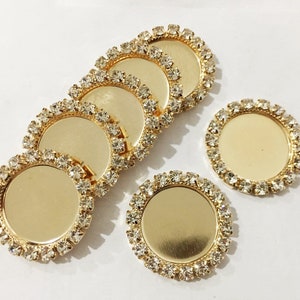 May include: Six gold-toned round metal trays with clear rhinestone borders. The trays are perfect for crafting and jewelry making.