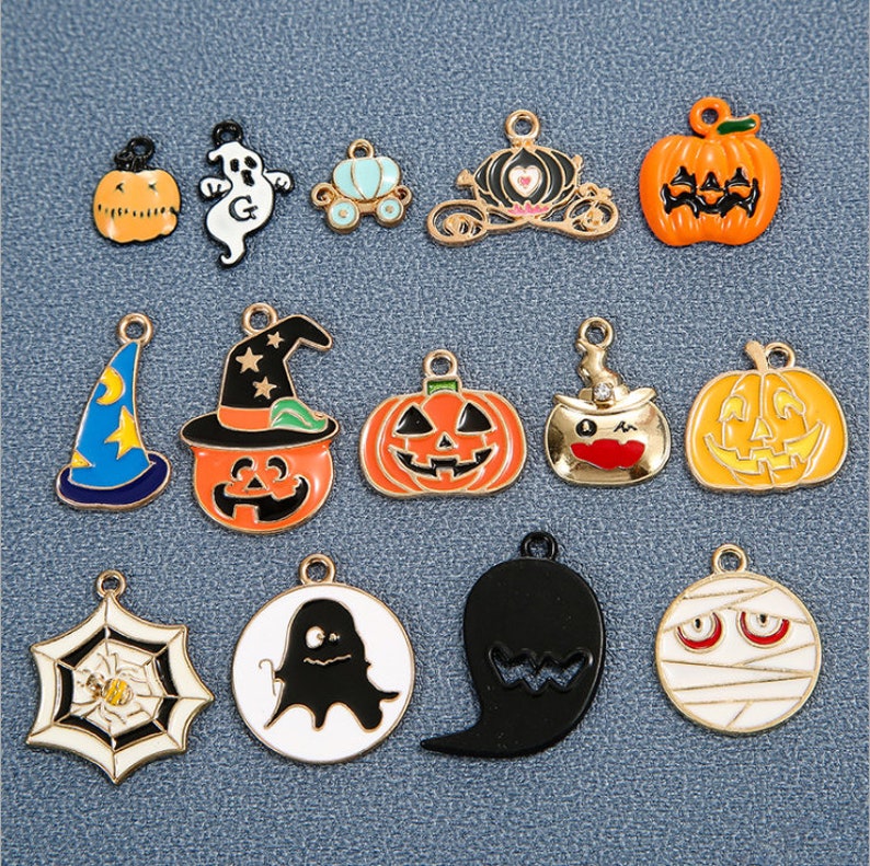 May include: Assortment of Halloween-themed charms featuring pumpkins, ghosts, witches, spiders, and mummies. The charms are made of metal and have a gold finish.