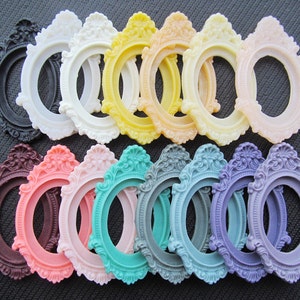 Puede incluir: Surtido de 15 marcos de fotos ovalados con detalles ornamentados. Los marcos son de varios colores, incluyendo negro, blanco, amarillo, rosa, turquesa, morado y marrón.