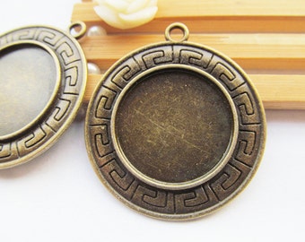 May include: Two antique gold-toned metal pendant trays with a decorative Greek key border. The trays are round and have a smooth, slightly textured surface.