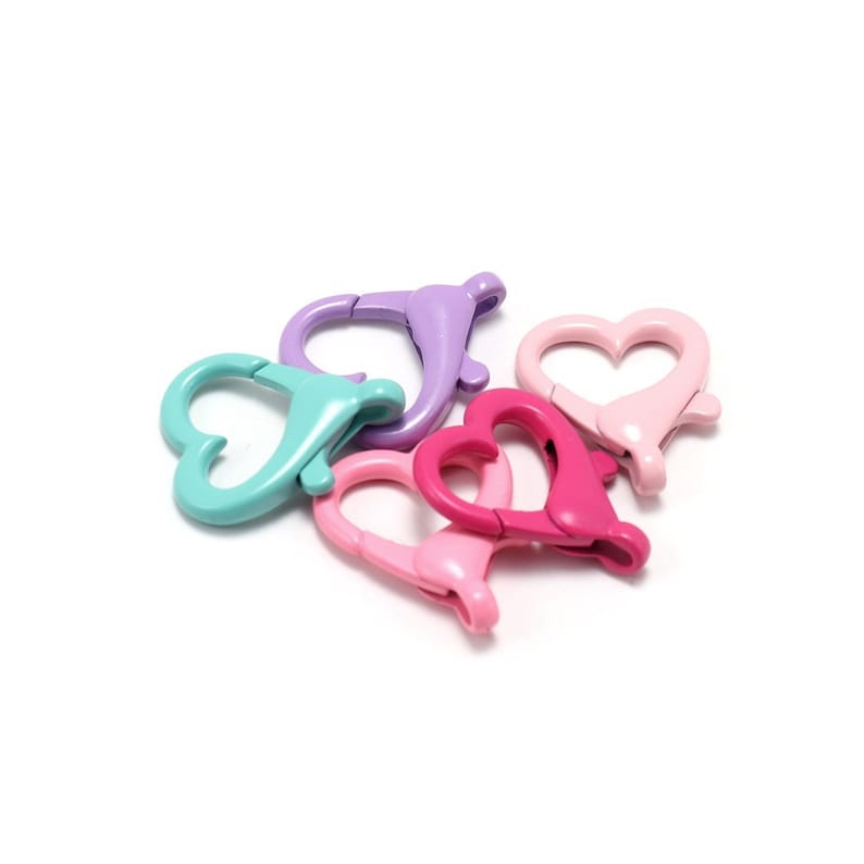 May include: Five heart-shaped metal clasps in various colours: light blue, pink, purple, and a darker pink. The clasps are designed for attaching to jewellery, bags, or other crafts.