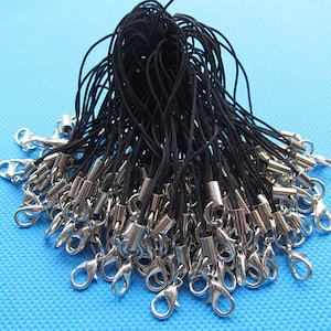 Op de afbeelding: Een bulkpakket met zwarte koord met zilveren karabijnhaken. Het koord is ongeveer 45 cm lang en is ideaal voor het maken van sleutelhangers, telefooncharms of andere kleine knutselprojecten.