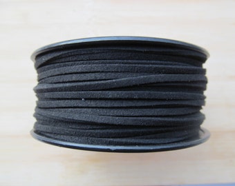 May include: A spool of black suede cord, wound tightly and ready for crafting projects.