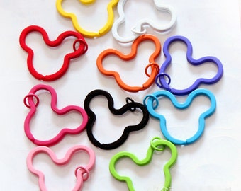 Puede incluir: Surtido de llaveros de metal de colores con forma de cabeza de Mickey Mouse. Los llaveros son de varios colores, incluyendo rojo, azul, verde, amarillo, rosa, naranja, negro y blanco.