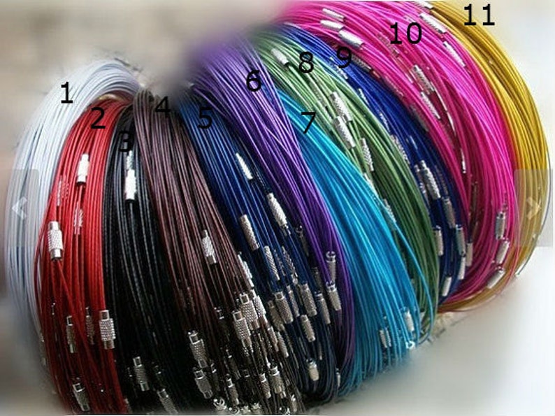 May include: A collection of 11 different colored cords with silver clasps. The cords are arranged in a rainbow pattern, starting with white and ending with gold.