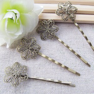 May include: Five bronze hair clips with a delicate floral design. Each clip features a detailed flower shape with a decorative openwork pattern.