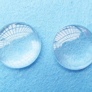 Peut inclure: Deux loupes en verre transparent sur une surface textur&eacute;e bleu clair.