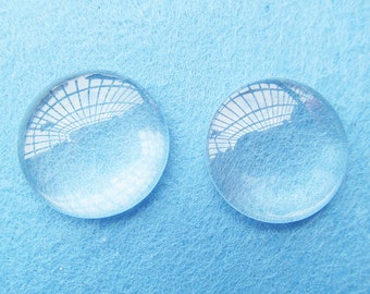 Pode incluir: Duas lupas de vidro transparente sobre uma superfície texturizada azul claro.
