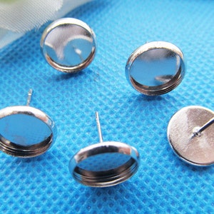 Puede incluir: Cuatro engastes para pendientes de color plateado con cabujones redondos de cristal transparente. Los engastes est&aacute;n dise&ntilde;ados para hacer pendientes personalizados.