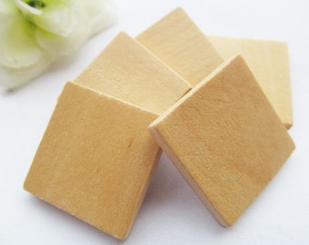 May include: Five unfinished, square wooden tiles stacked on top of each other. The tiles are a light brown color.