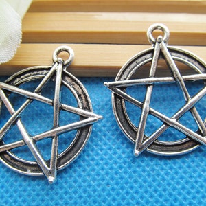 May include: Two silver-toned metal charms in the shape of a pentagram, each with a circle around the star. The charms are perfect for jewelry making or crafting.