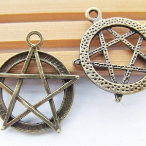 May include: Two antique bronze metal charms in the shape of a five-pointed star. One charm has a solid star design, while the other has a star design with an open center.