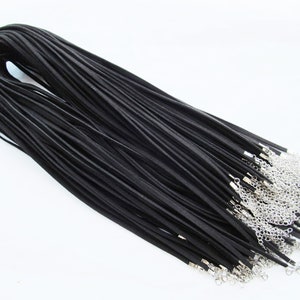 May include: A bulk pack of 50 black leather cord necklaces with silver lobster clasps. Each cord is approximately 18 inches long.