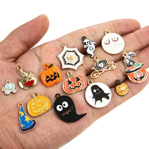May include: Assortment of Halloween-themed charms, including pumpkins, ghosts, witches hats, a spider web, and a mummy. The charms are made of metal and have a gold finish.