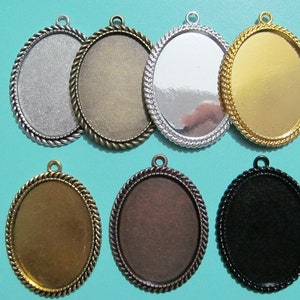 Peut inclure: Sept plateaux ovales en métal pour pendentif avec une bordure en forme de corde. Les plateaux sont en argent, or, bronze et noir.