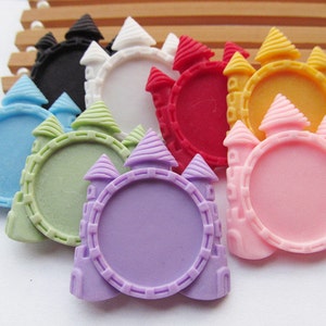 Puede incluir: Surtido de cabujones de resina de forma de castillo de colores con un centro redondo abierto. Los cabujones son de varios colores, incluyendo azul, verde, morado, rosa, rojo, amarillo y blanco.
