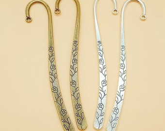 May include: Four metal bookmarks with a floral design. Two bookmarks are gold and two are silver.