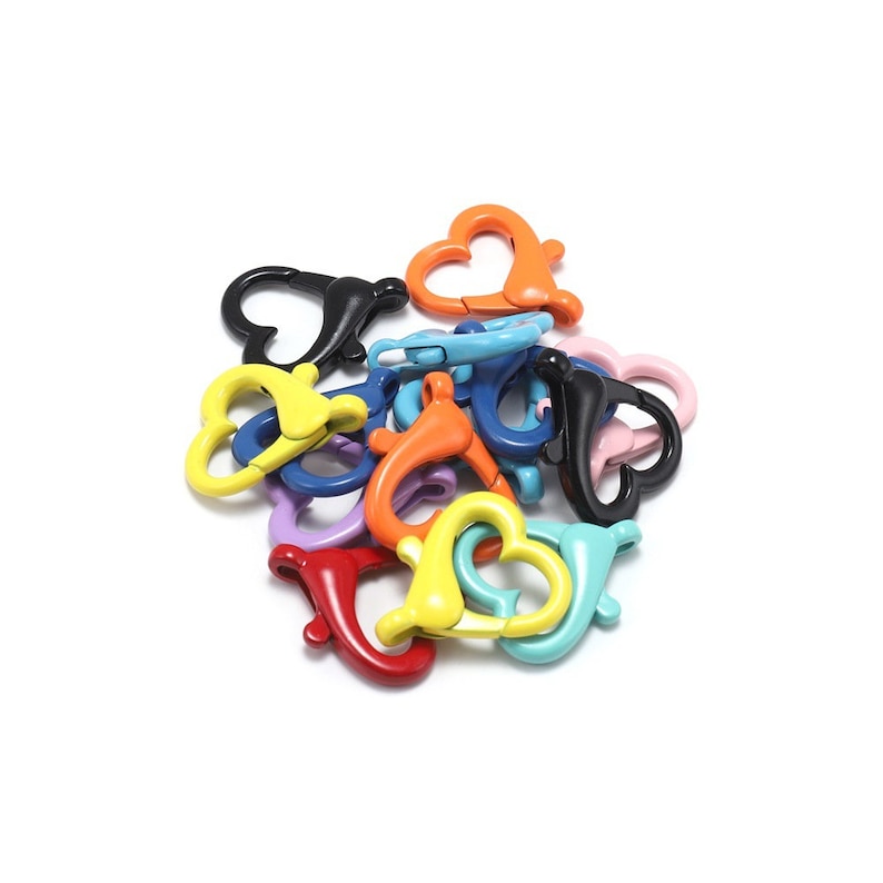 May include: Assortment of colourful heart-shaped metal clasps. The clasps are in various colours, including red, orange, yellow, green, blue, purple, and black.