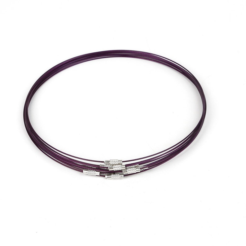 May include: A set of six purple wire necklaces with silver clasps. The necklaces are layered and arranged in a circle.