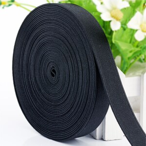 May include: A roll of black elastic trim, a type of fabric used for sewing and crafting projects.