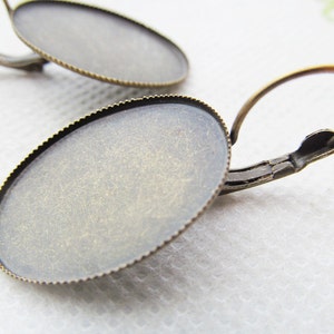 May include: A pair of antique brass earring blanks with a round, scalloped edge. The blanks are ready to be customized with your own designs.