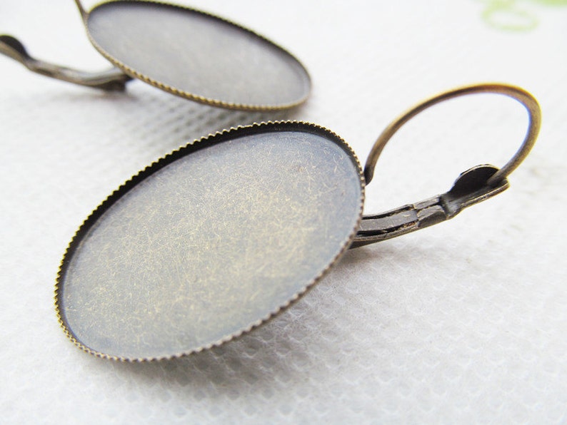 May include: A pair of antique brass earring blanks with a round, scalloped edge. The blanks are ready to be customized with your own designs.
