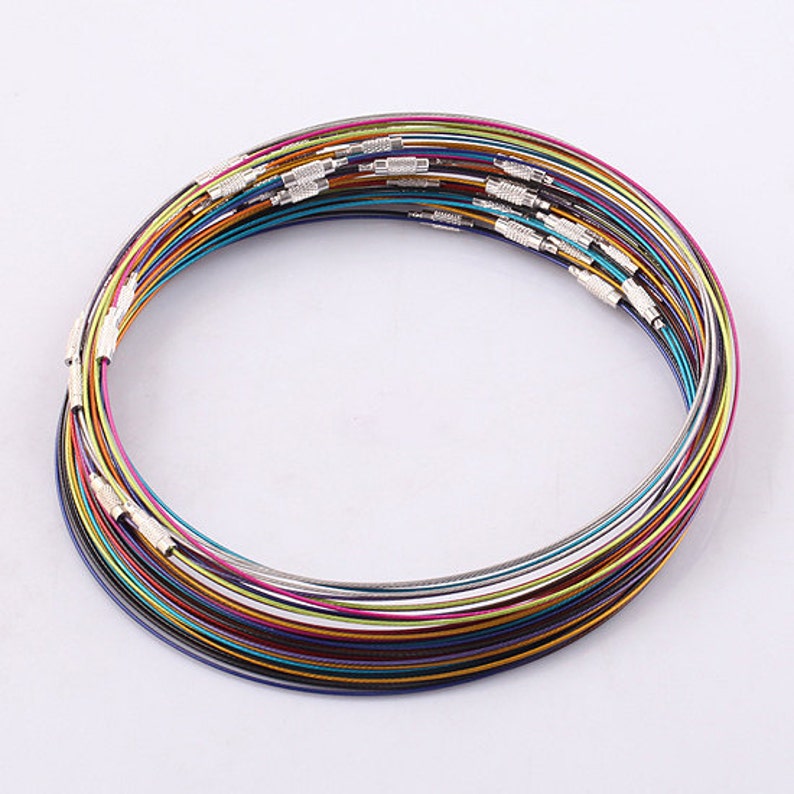 May include: A stack of colorful metal necklaces, each with a silver clasp. The necklaces are arranged in a circle, with the clasps facing outward.